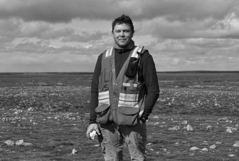 A man standing in front of grass